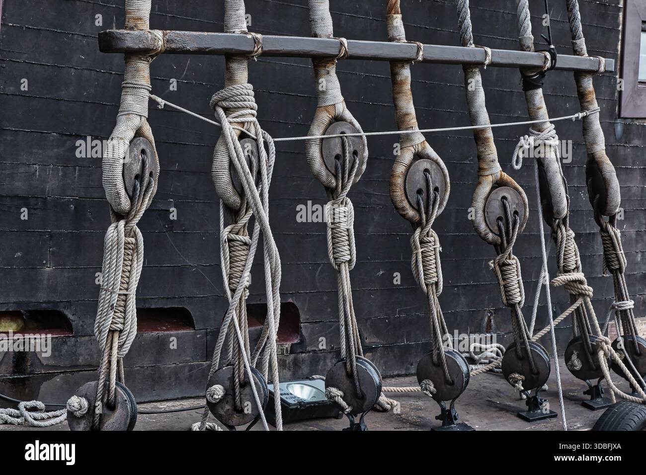 Close-up Of Rigging And Ropes On An Old Sailing Ship, Showing Detailed Knots And Wooden Pulleys. Stock Photo