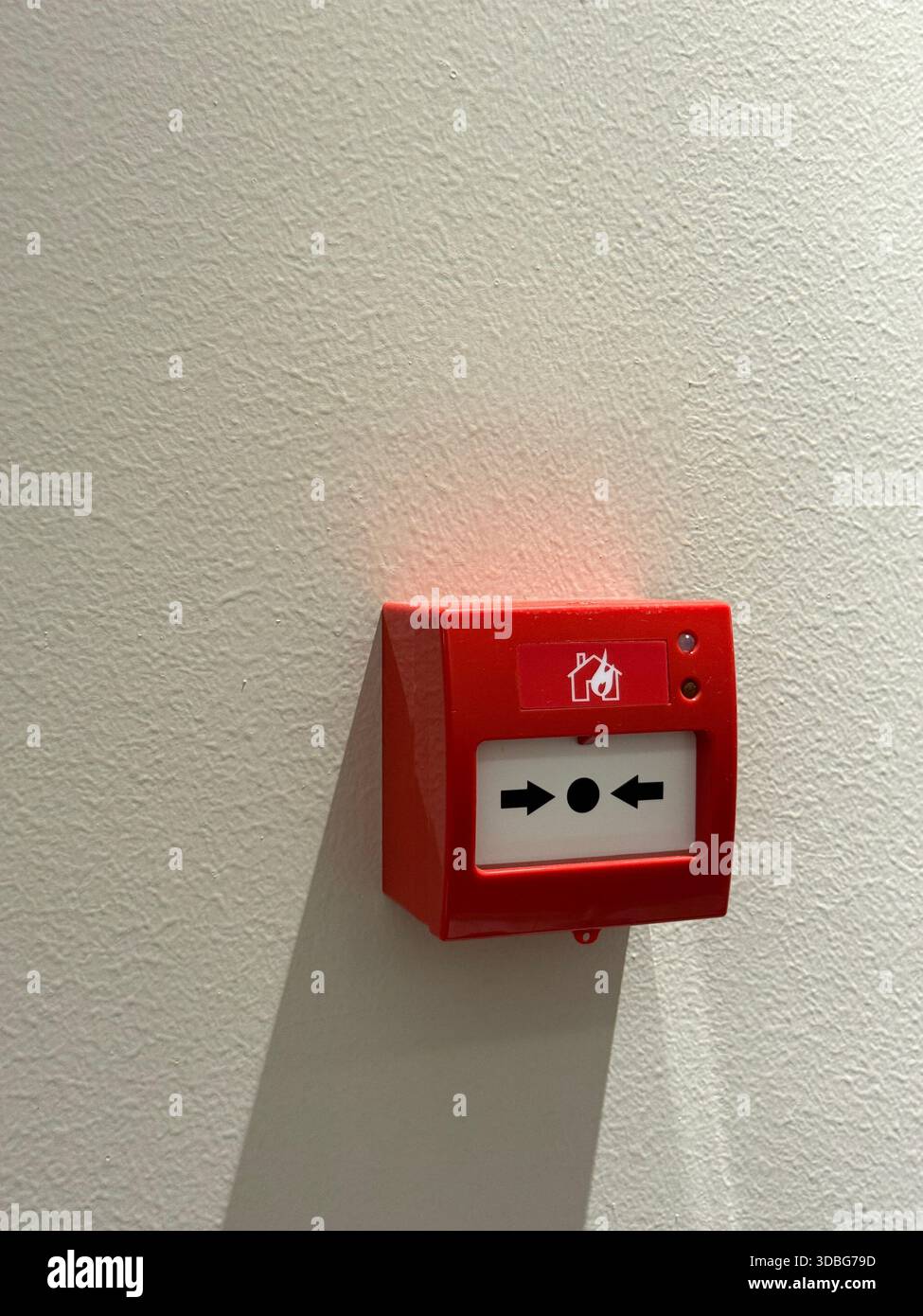 Fire alarm button on white wall with sunlight shadow, suitable as ...