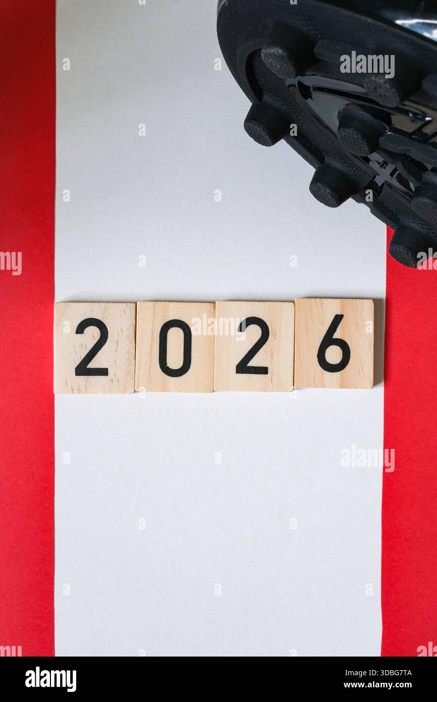 Detail of a black football boots with spikes. Wooden numbers 2026 ...