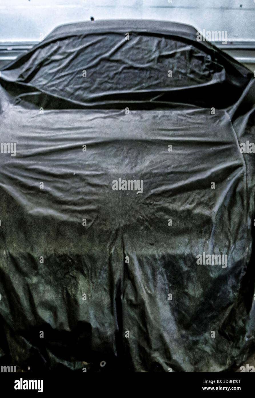 A car under wraps in a garage Stock Photo
