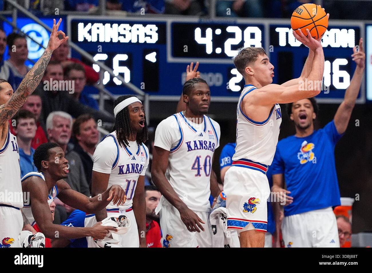 Kansas players on the bench watch as guard Kohl Rosario (7) shoots a ...