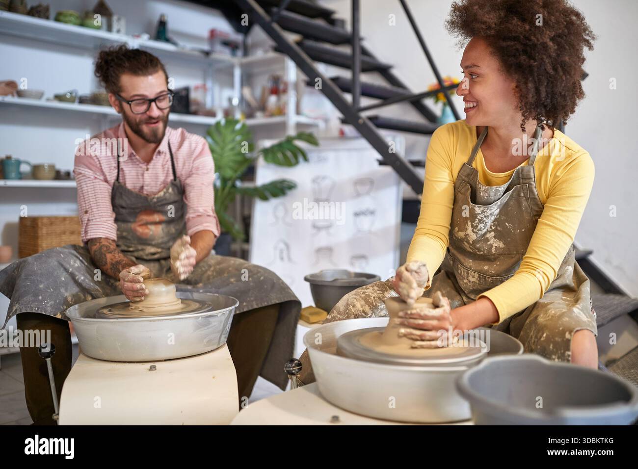 young Smiling creative artists making Handmade pottery in studio. Creative, hobby ,workshop concept Stock Photo