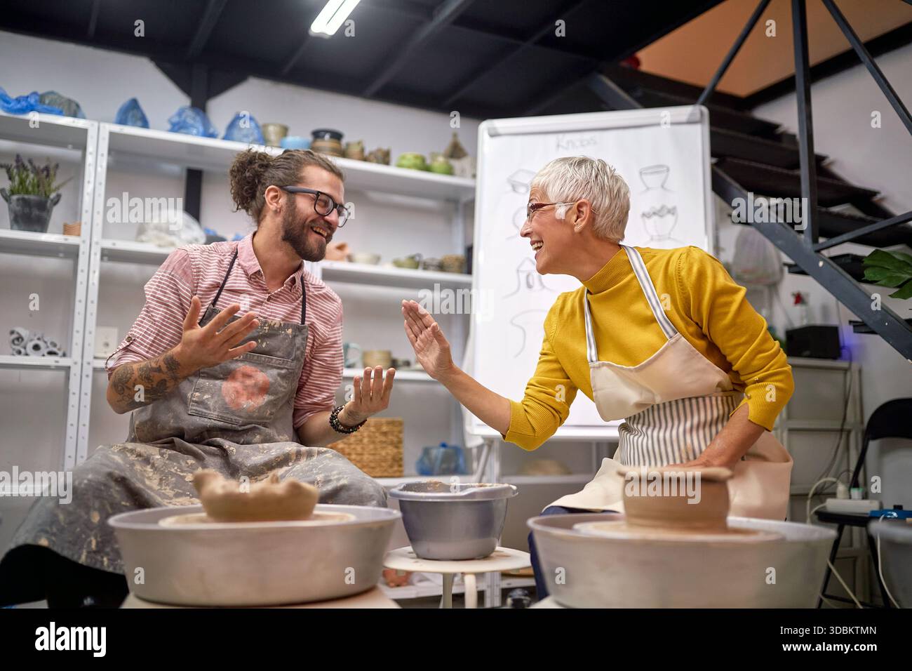 smiling Artists having fun while making pots from clay in studio. . Modeling ,project.  Creative, hobby ,workshop  concept Stock Photo