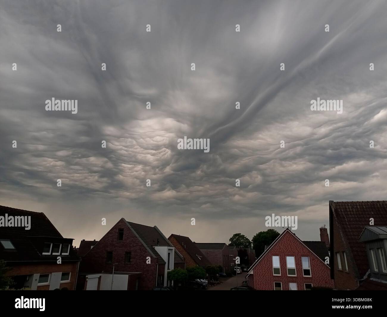 Dark storm clouds over houses Stock Photo