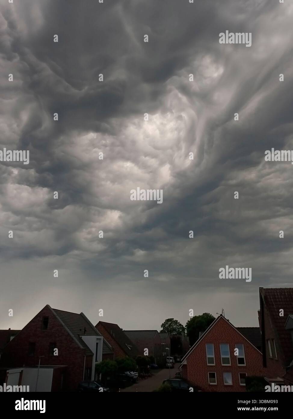 Dark storm clouds over houses Stock Photo