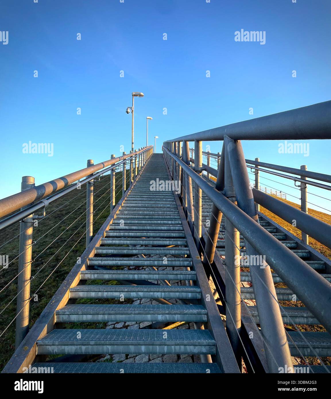 Metal staircase leading upwards with railings under clear blue sky - Smartphone Captured Stock Image