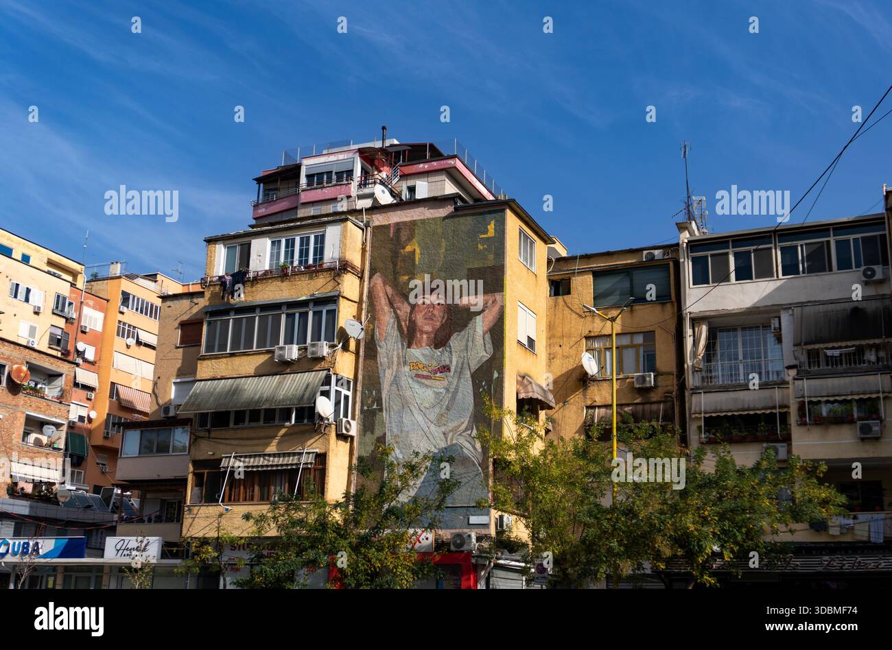 A large mural of a woman on the exterior of a residential building in Tirana, Albania - Stock Image