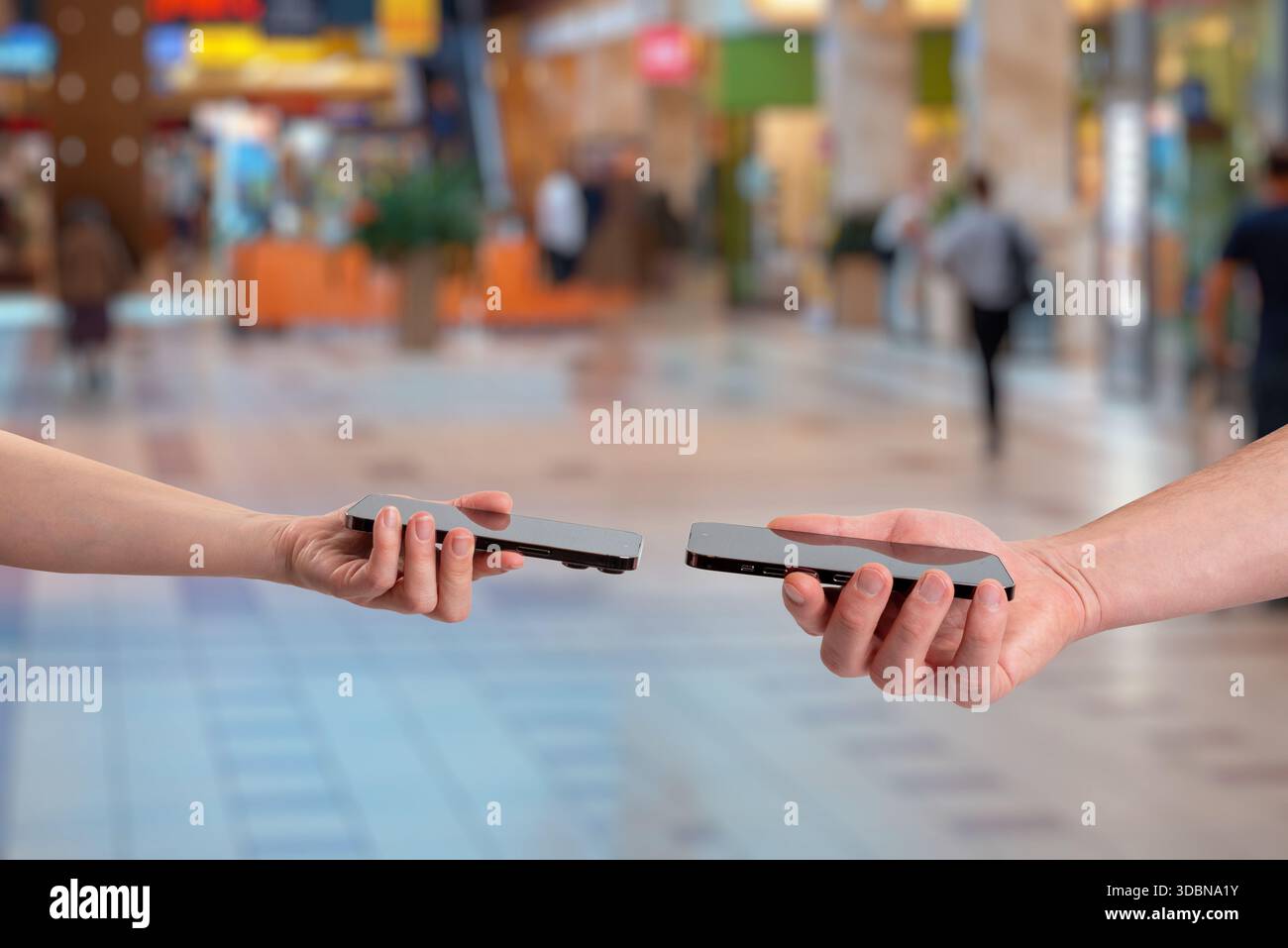 Wireless data exchange between two smartphones using close range communication, representing contact sharing, phone number transfer, digital identity, Stock Photo