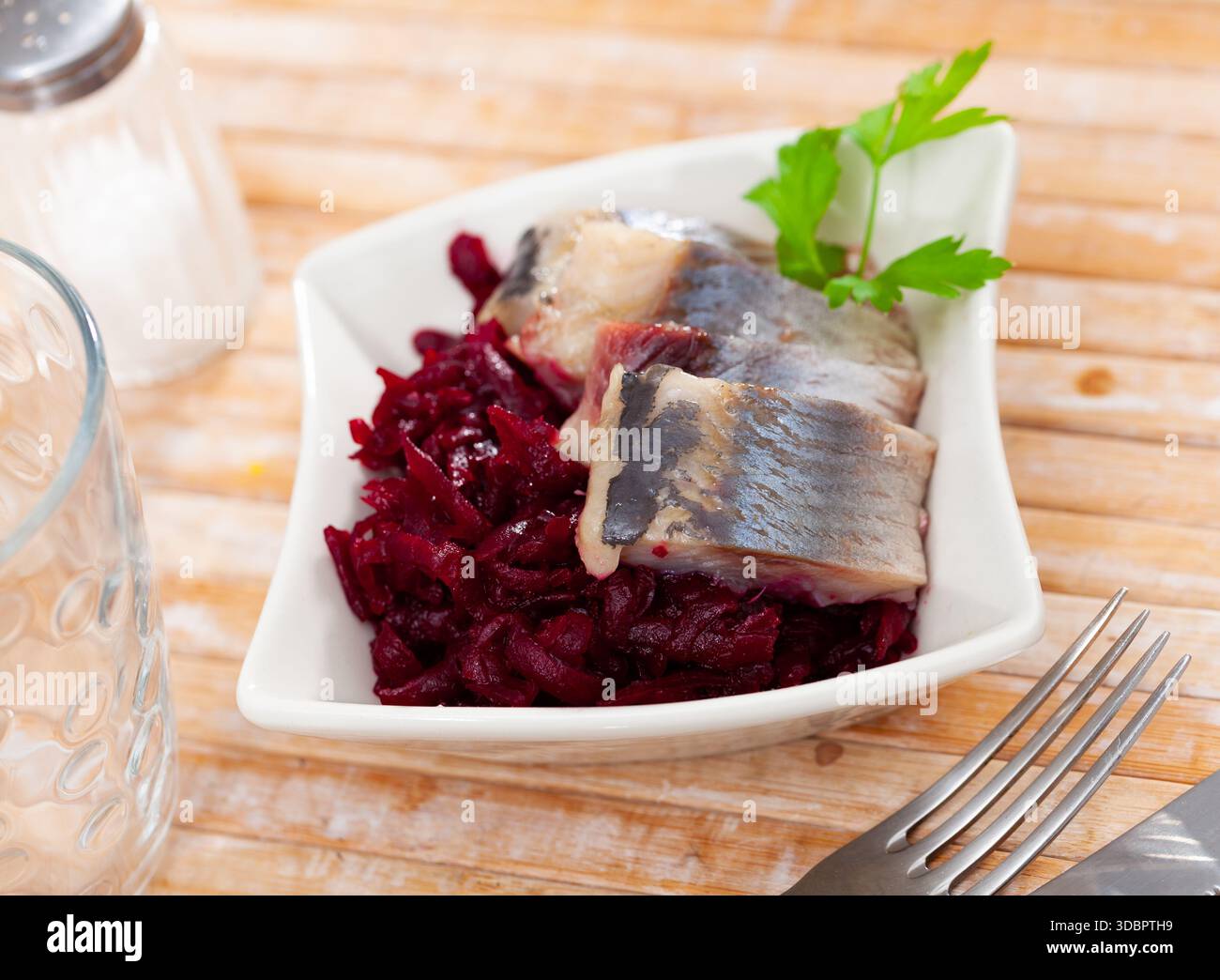 Sliced herring with grated beetroot served on table Stock Photo