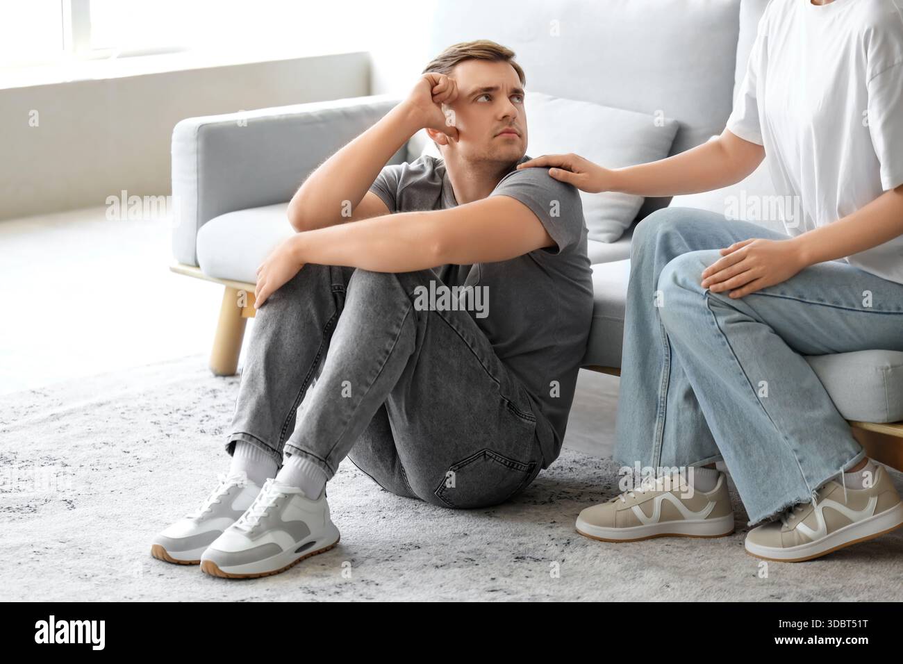 Young woman supporting man with suicidal thoughts at home Stock Photo