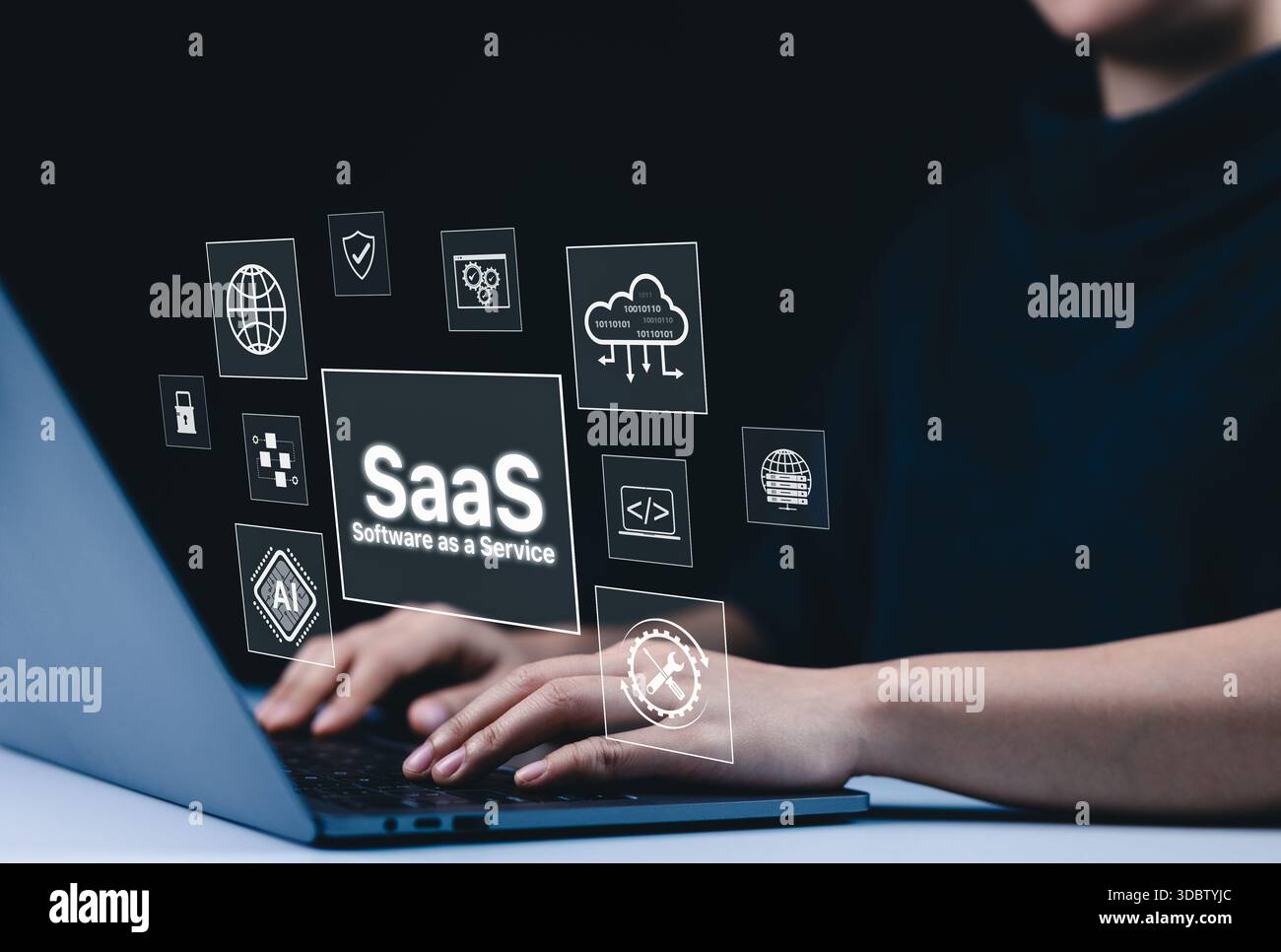 SaaS Cloud Computing and Software as a Service Concept. A person using a laptop with virtual interface icons showing SaaS, cloud computing, AI, and so Stock Photo