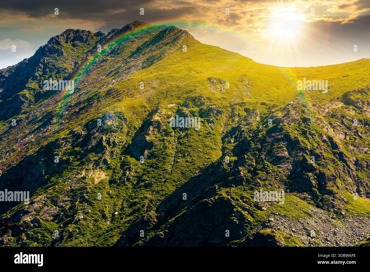 mountain landscape in summer at sunset. ridge under blue sky with clouds in evening light. alpine scenery with rocky peaks and steep slopes. storytell Stock Photo