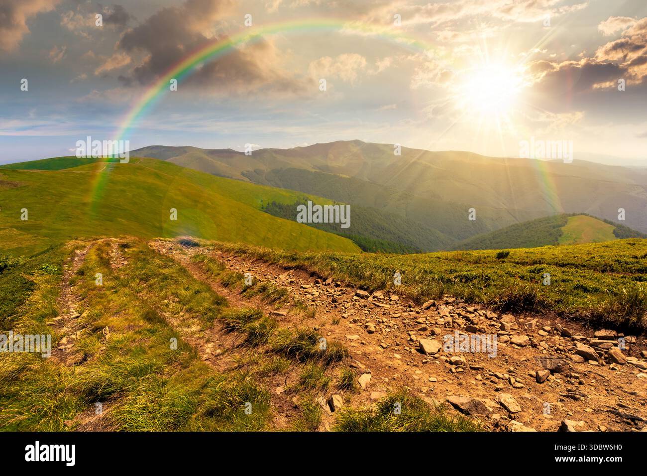 green rolling hills of mountain ridge at sunset. grassy alpine meadows and sky with clouds in evening light. summer landscape of highlands. distant pe Stock Photo