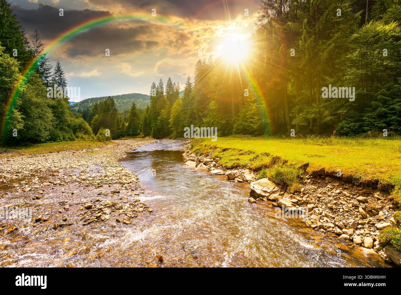 landscape with mountains, forest and a river in front at sunset. beautiful scenery in summer in evening light. water flowing through ecology and susta Stock Photo