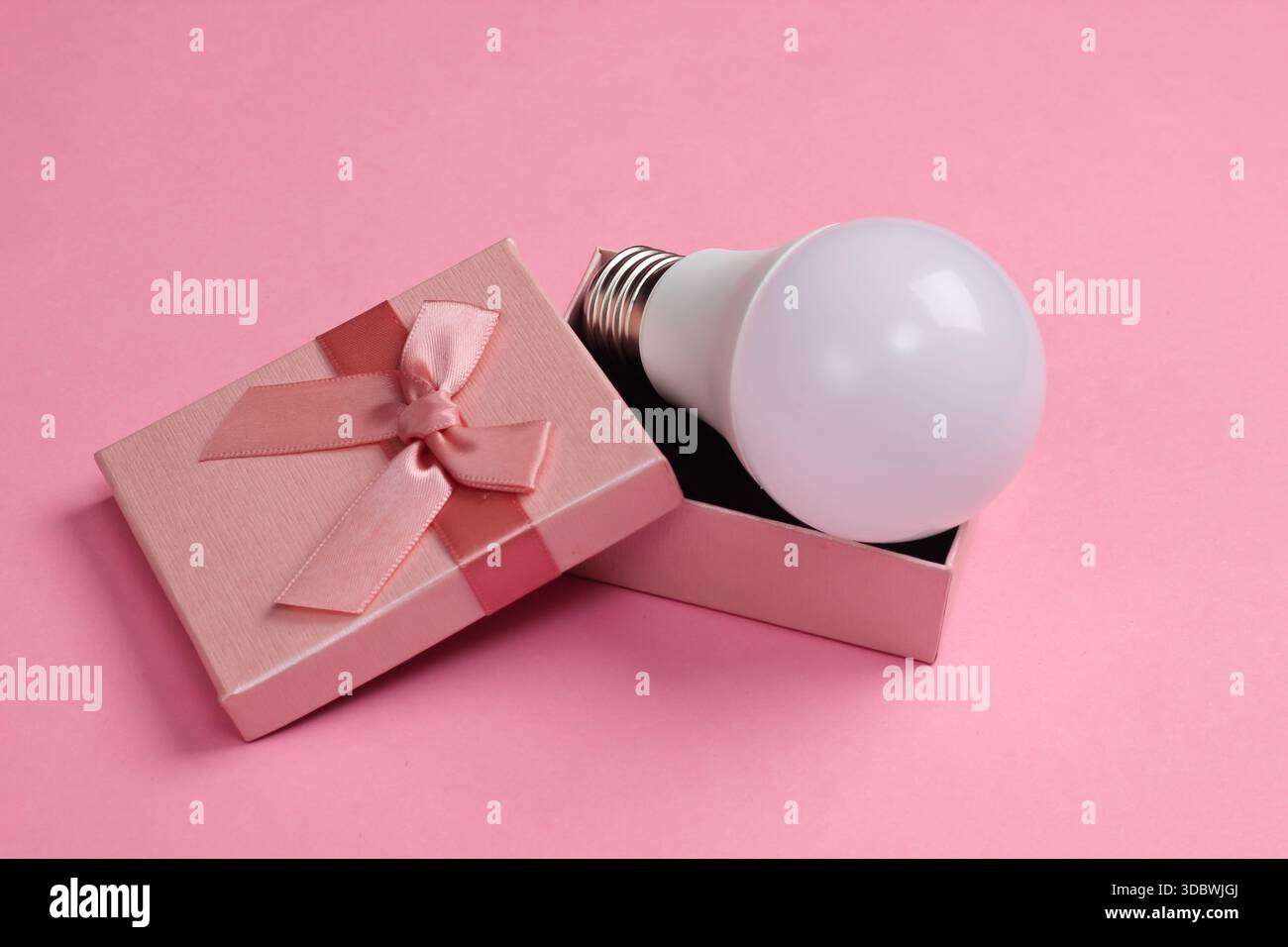 LED light bulb in a gift box on a pink background Stock Photo