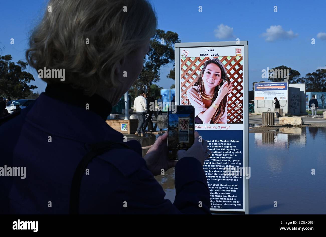 Shani Lock PRODUCTION - 17 December 2025, Israel, Re'im: A woman takes a photo of ...