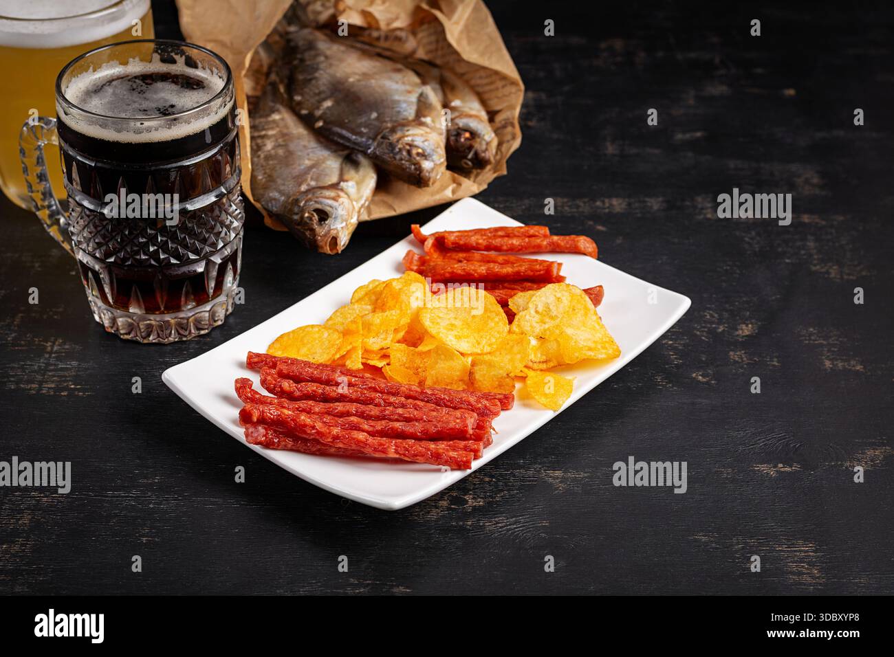 Beer and snack, chips and kabanos on a dark background. Stock Photo
