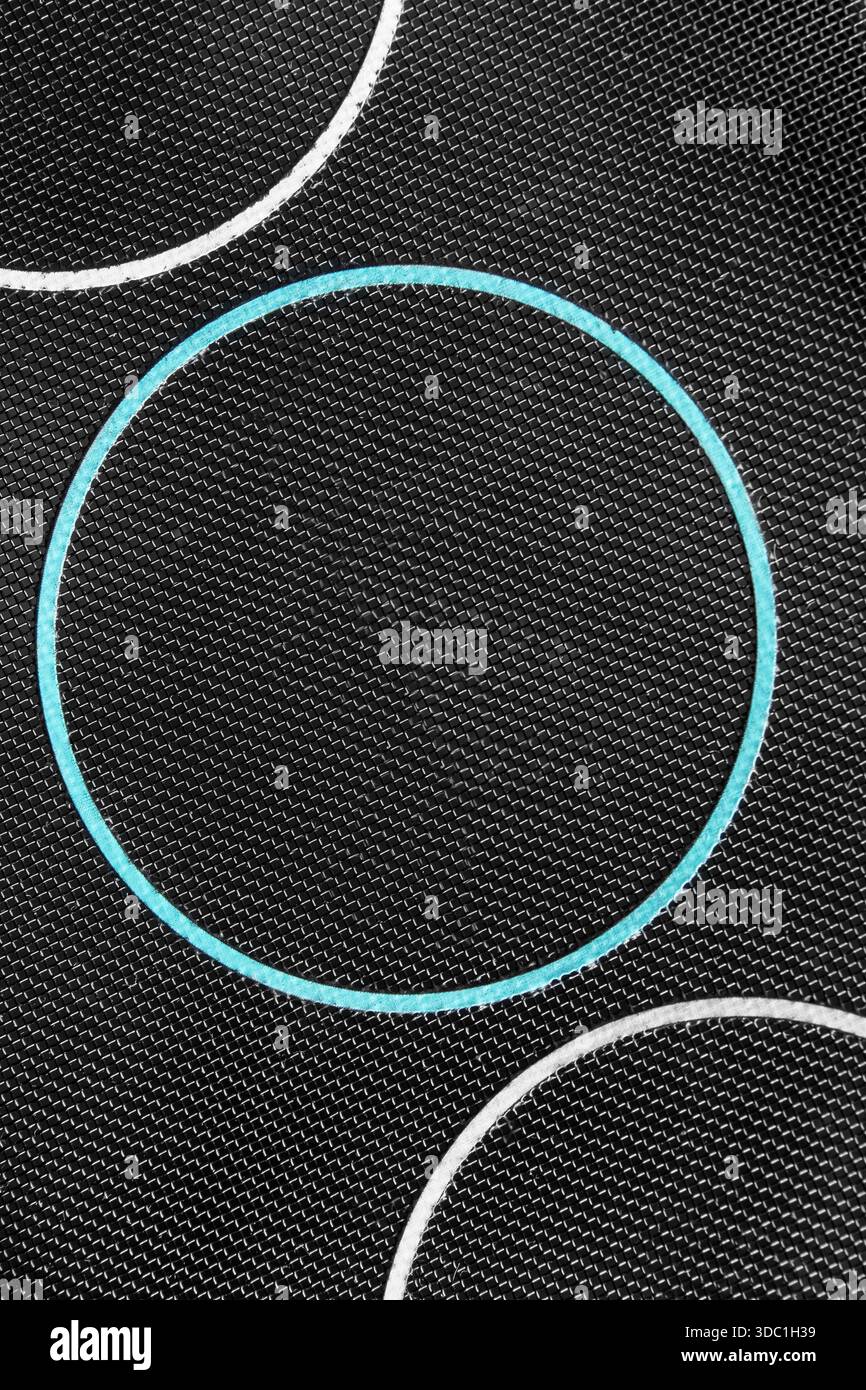 Ring shaped light blue frame on black netting fabric background closeup Stock Photo