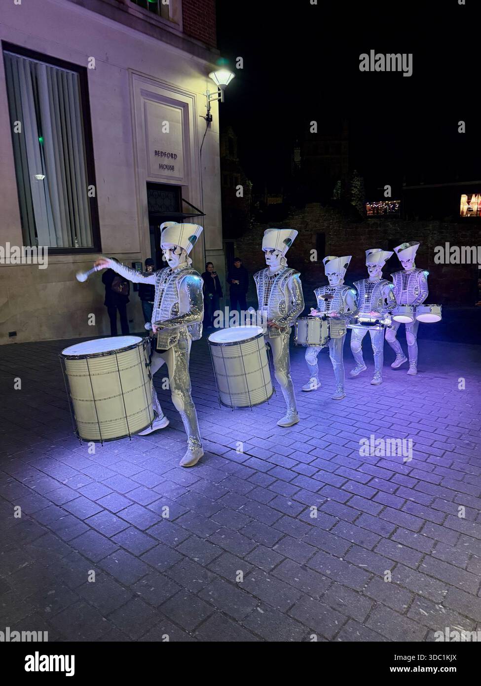 SPARK! LED drummers performing in Princesshay, Exeter at night, dressed in illuminated futuristic costumes during a festive event. - Smartphone Captured Stock Image