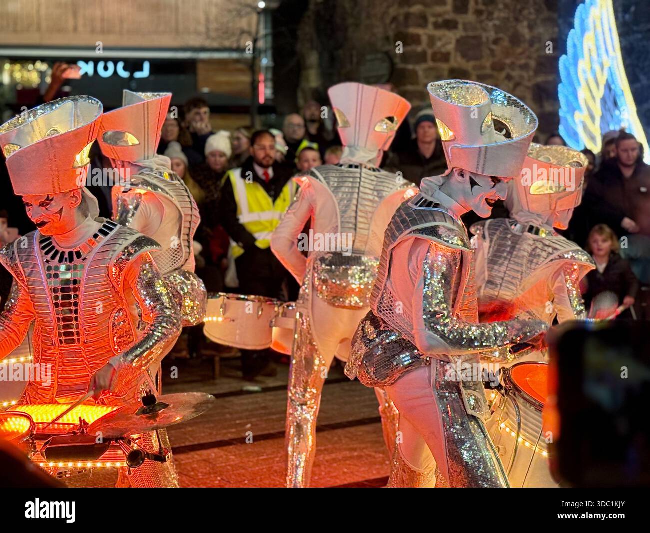 SPARK! LED drummers performing at a Christmas event in Princesshay, Exeter, with glowing instruments and a festive crowd watching. - Smartphone Captured Stock Image