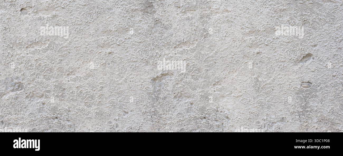 Rough gray concrete plaster creating an aged textured wall surface Stock Photo