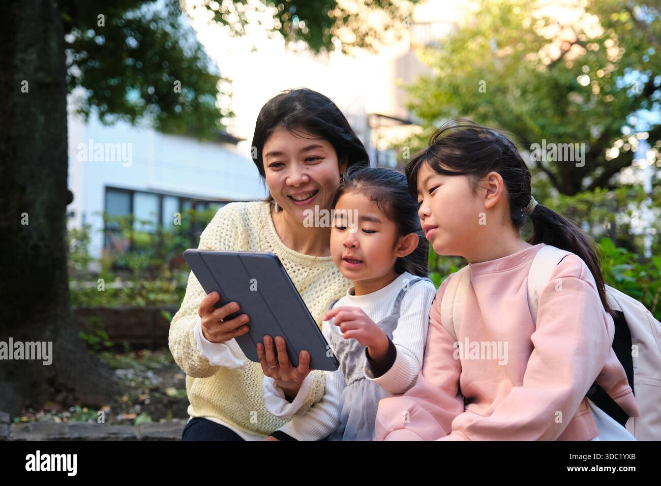 Japanese mother and daughters learning together using digital tablet Stock Photo