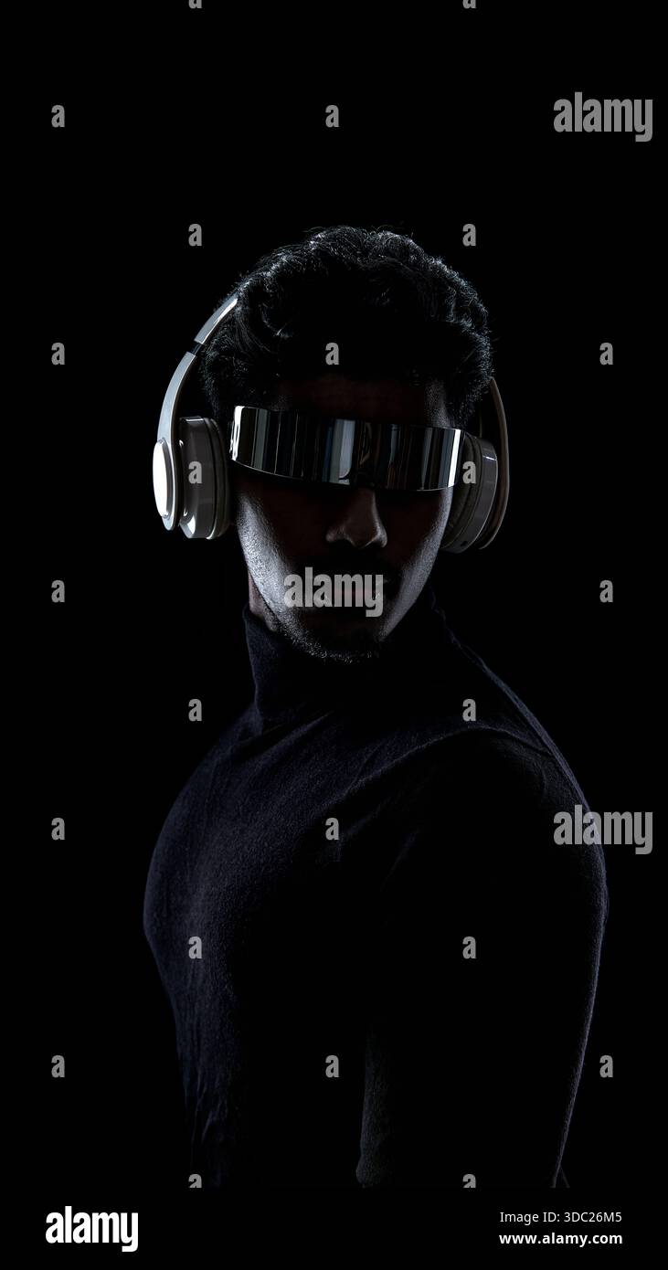 Front view portrait of man with futuristic visor and headphones on black background Stock Photo