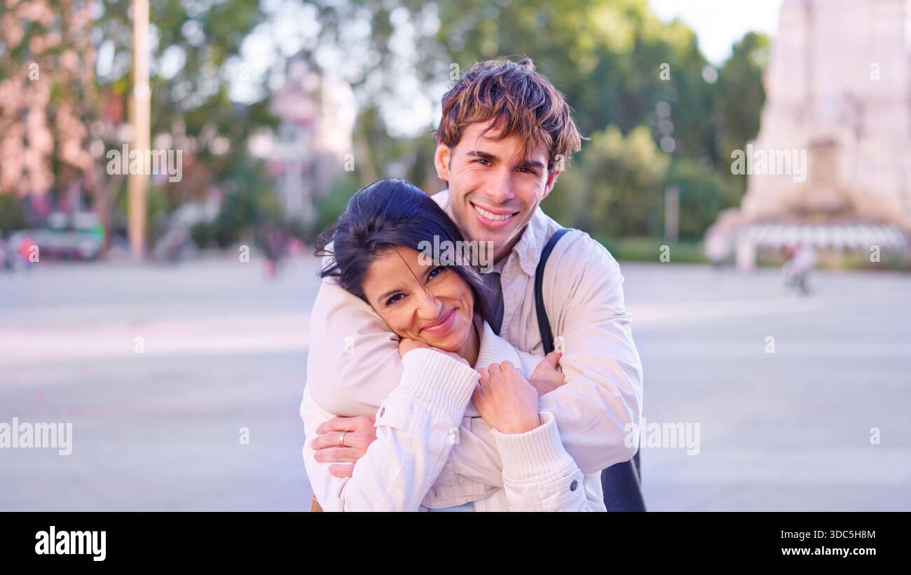 Happy diverse couple embracing outdoors in city Stock Photo