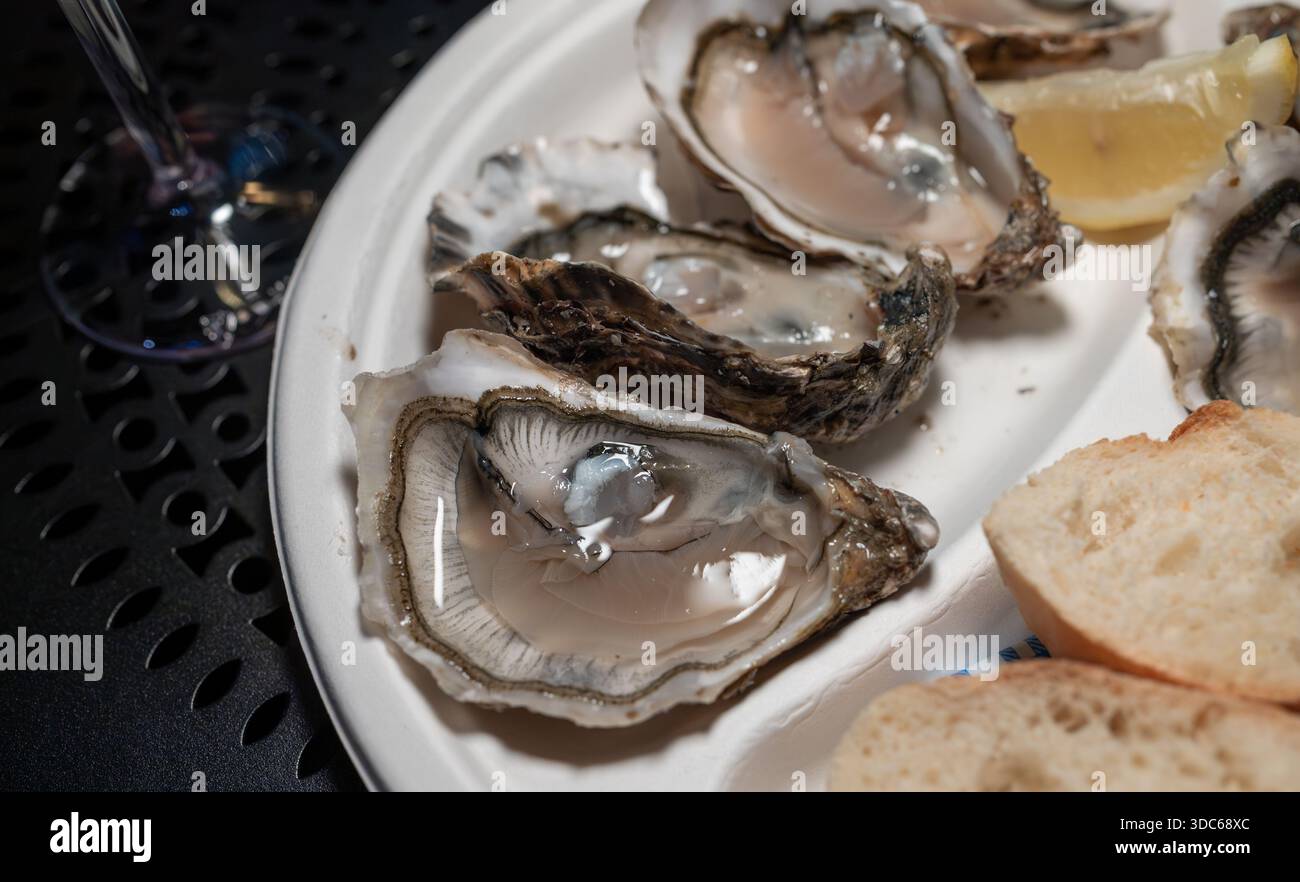 Fresh oysters in shells on French weekly market, street food, portion of  opened alive oysters with piece of lemon to eat on market, seafood, France  Stock Photo - Alamy, image size:1300x882