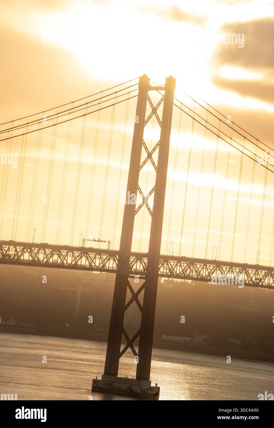 Lissabon, Portugal – Brückenturm der Ponte 25 de Abril im goldenen Morgenlicht über dem Tejo Stock Photo