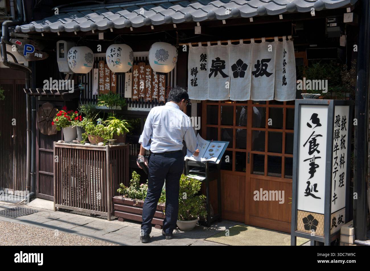 Man at Izumizaka Hida beef teppanyaki-style Japanese restaurant fa?ade with noren shop curtain in Gujo-Hachiman (���ϰ��) in Gifu Prefecture, Japan. Stock Photo