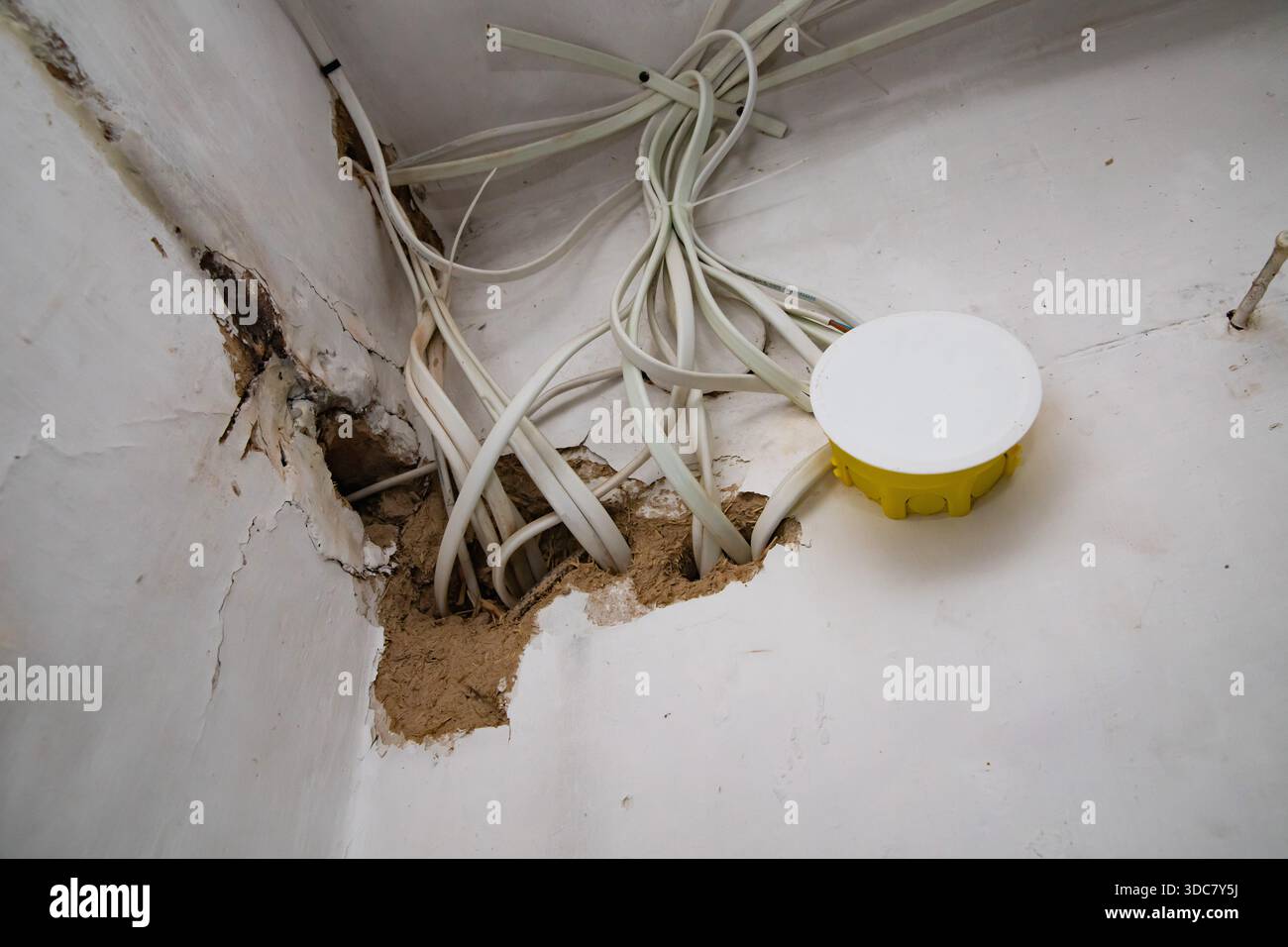 Electrical wiring cables and junction box exposed inside damaged wall ...