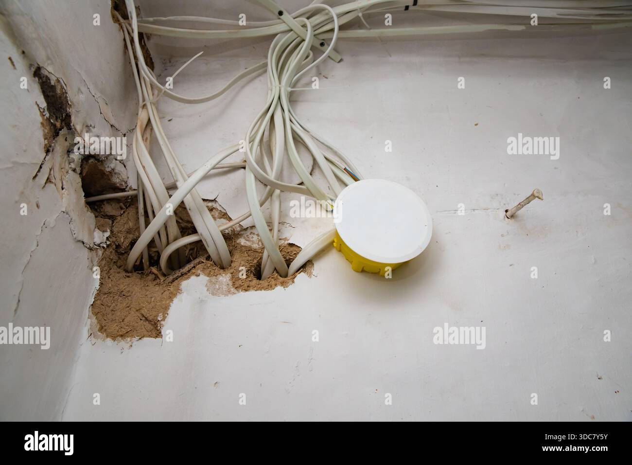 Electrical wiring cables and junction box exposed inside damaged wall ...