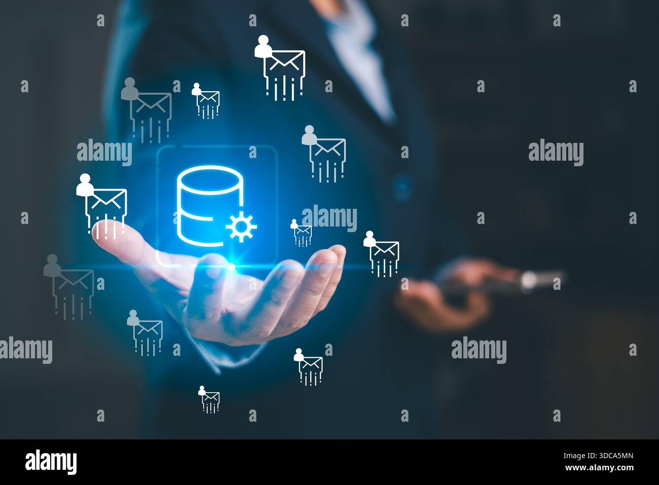 A business professional presenting glowing database icon with email user symbols, illustrating data processing, digital communication, cloud technolog Stock Photo