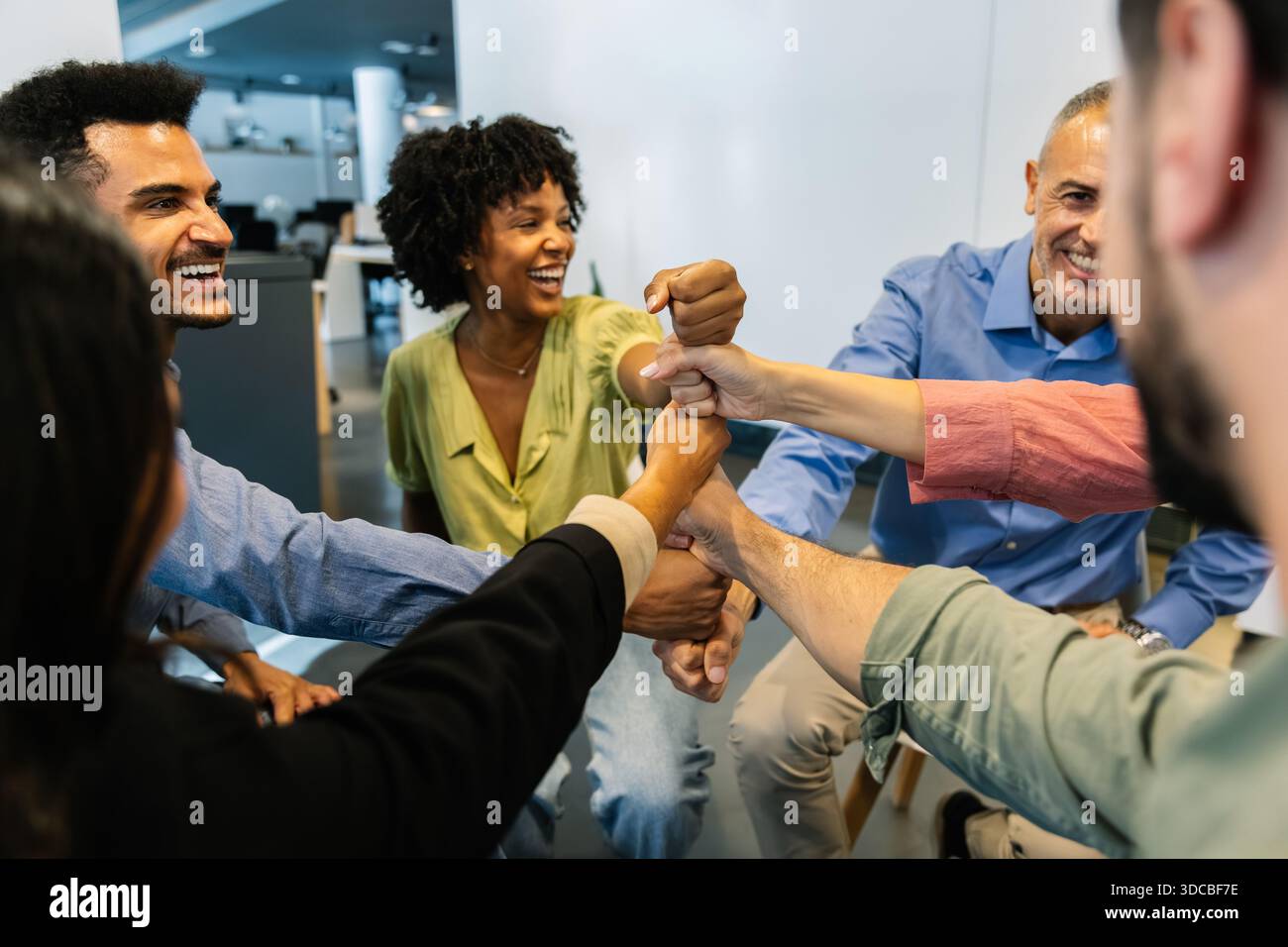 Diverse business team stacking fists showing unity Stock Photo