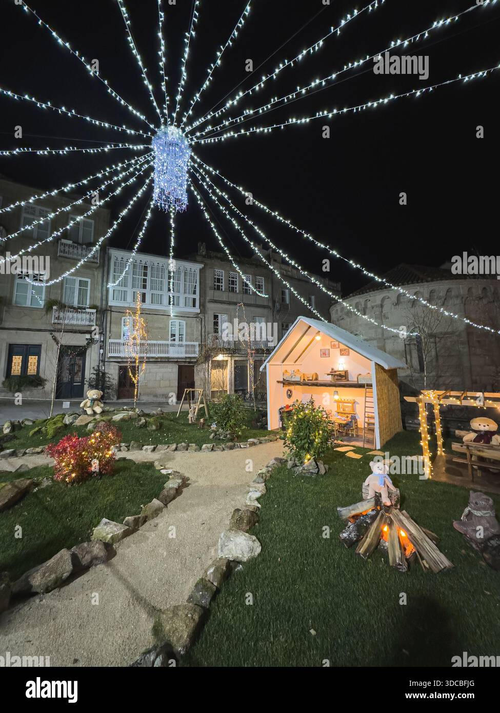 Night-time Christmas scene featuring an illuminated nativity display. Outdoor installation in the historic center of Allariz, part of the twelve theme - Smartphone Captured Stock Image