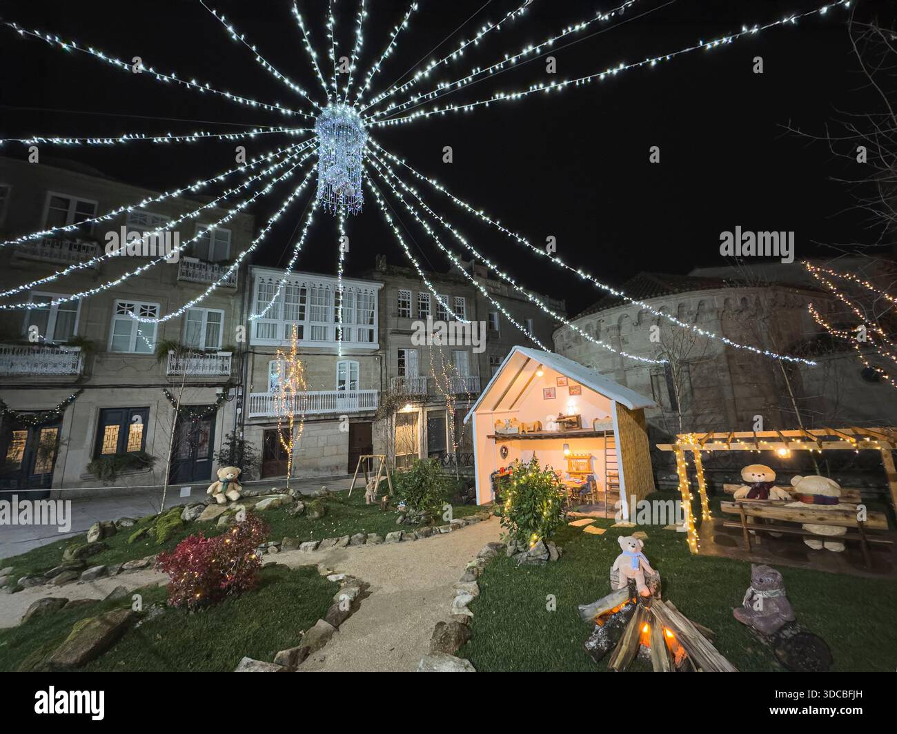 Night-time Christmas scene featuring an illuminated nativity display. Outdoor installation in the historic center of Allariz, part of the twelve theme - Smartphone Captured Stock Image