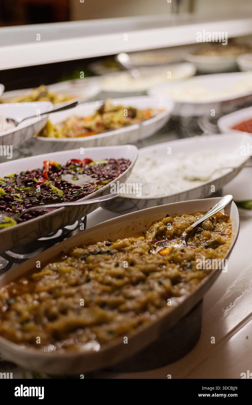Different types of food are shown in serving dishes at a buffet. The ...