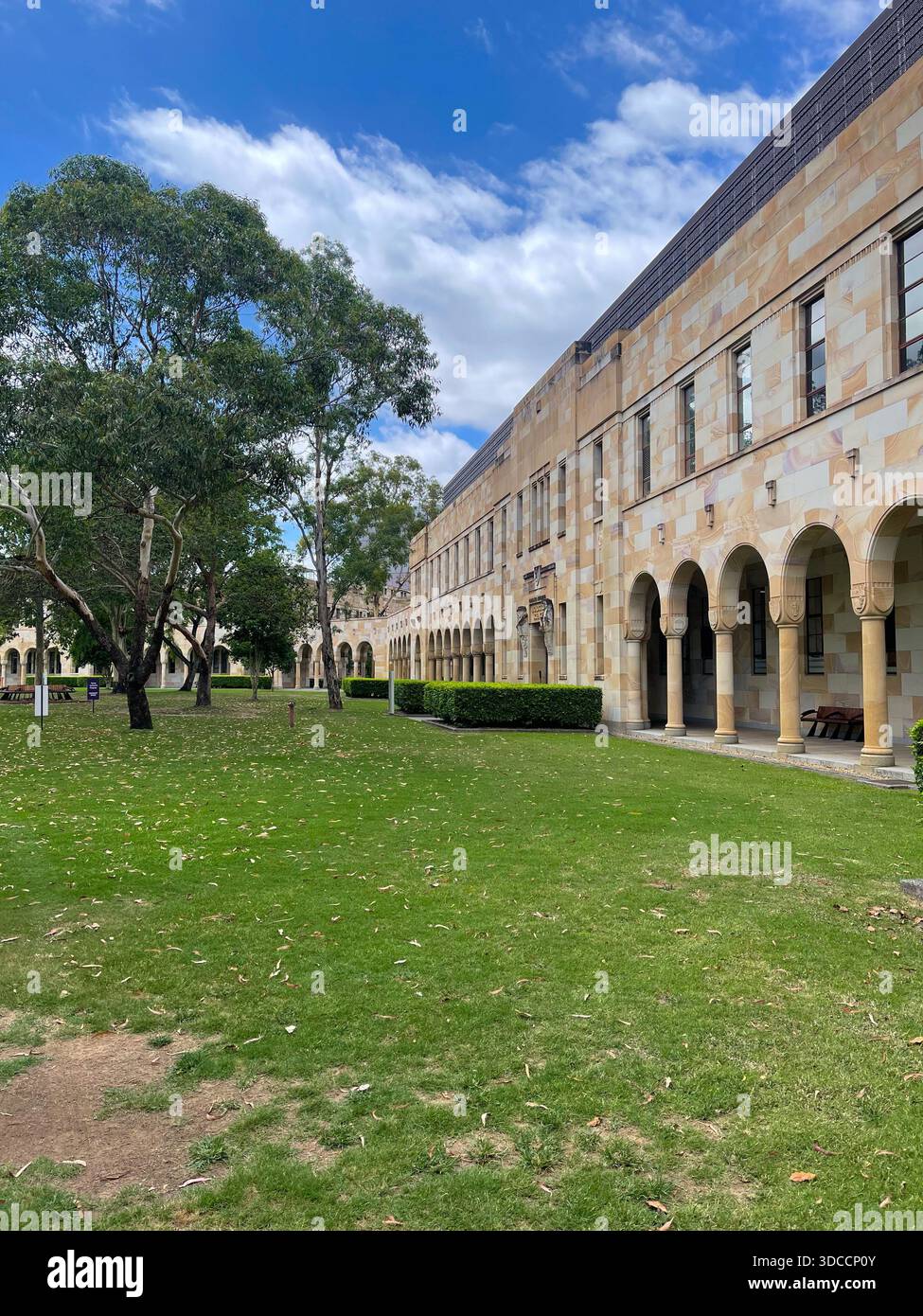 Historic sandstone architecture of the University of Queensland's Great Court cloisters and lawn, Brisbane, Australia - Smartphone Captured Stock Image