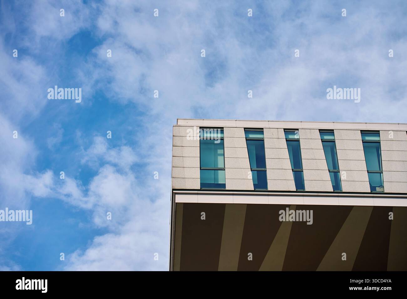 Modern geometric office building facade with glass windows, light ...