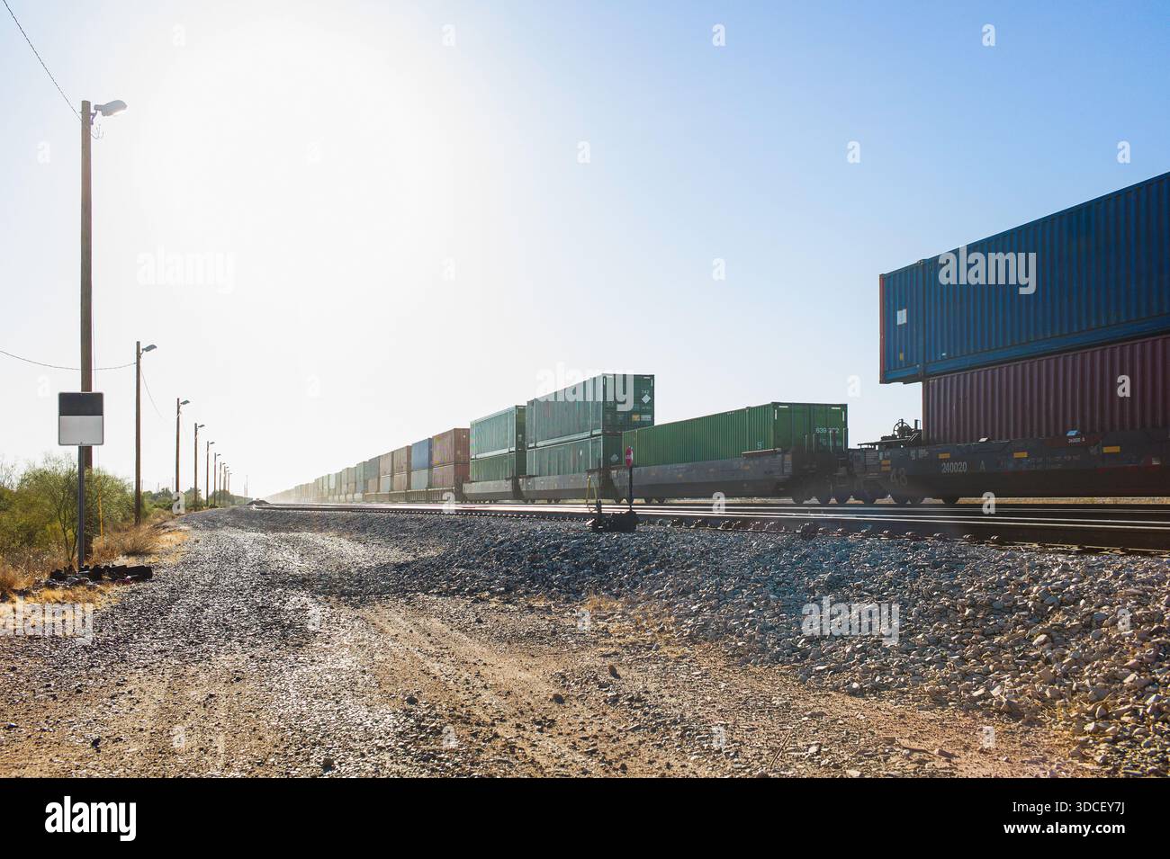 3 Stack Container Train Container stack train passing empty yard looking into sun Stock Photo ...