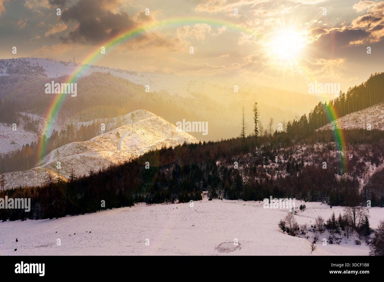 winter landscape with snow covered forested hills at sunset. mountains in cold weather in evening light. rural scene. christmas holiday in alpine regi Stock Photo