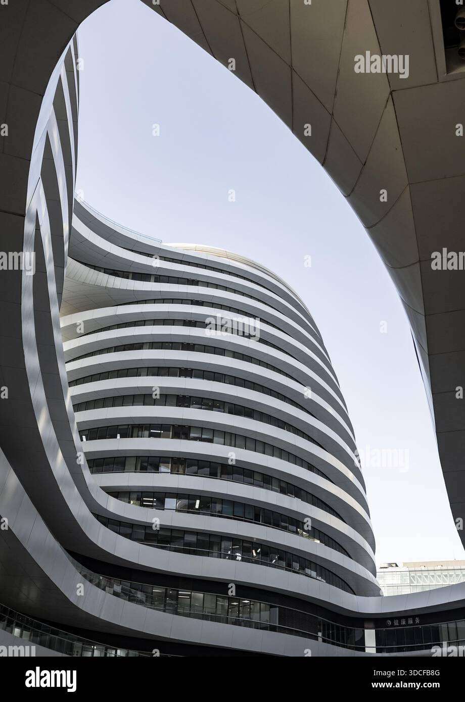 View of a modern, multi-story building with curved lines and white ...