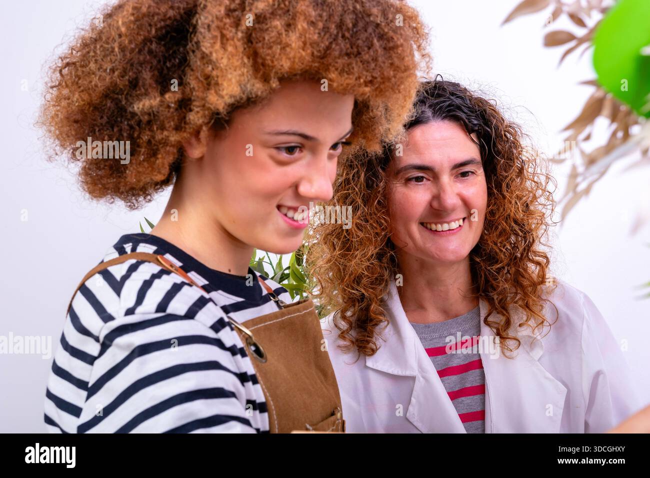 Two smiling women collaborating on a task, expressing happiness and teamwork Stock Photo