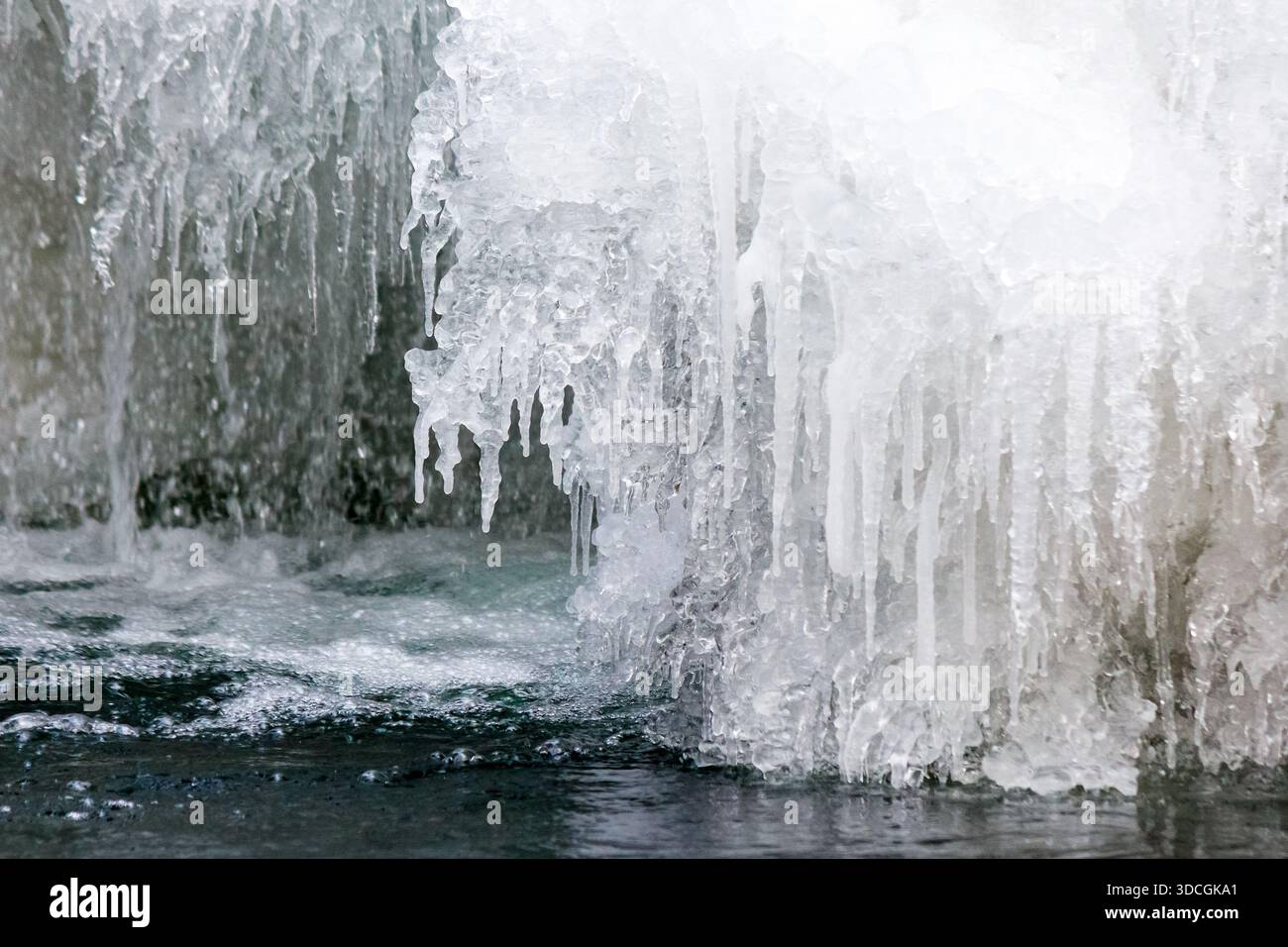 frozen waterfall close up view. icicles hanging above water. cold winter landscape photography on river tyrychka of transcarpathia ukraine. seasonal n Stock Photo