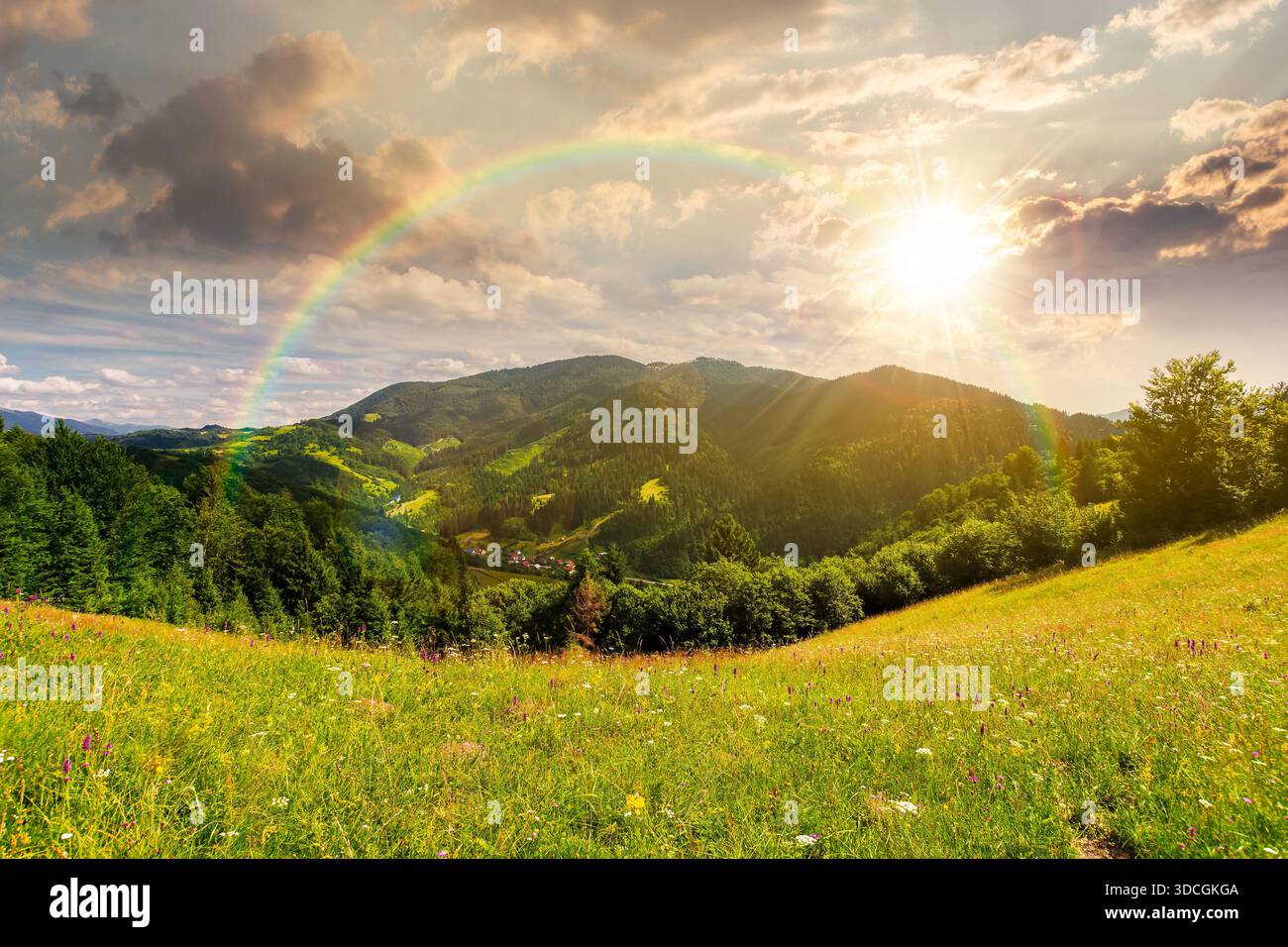 beautiful mountain landscape in summer at sunset. grassy meadow on rolling hills in evening light. ridge in the distance. sunny weather clouds on sky. Stock Photo