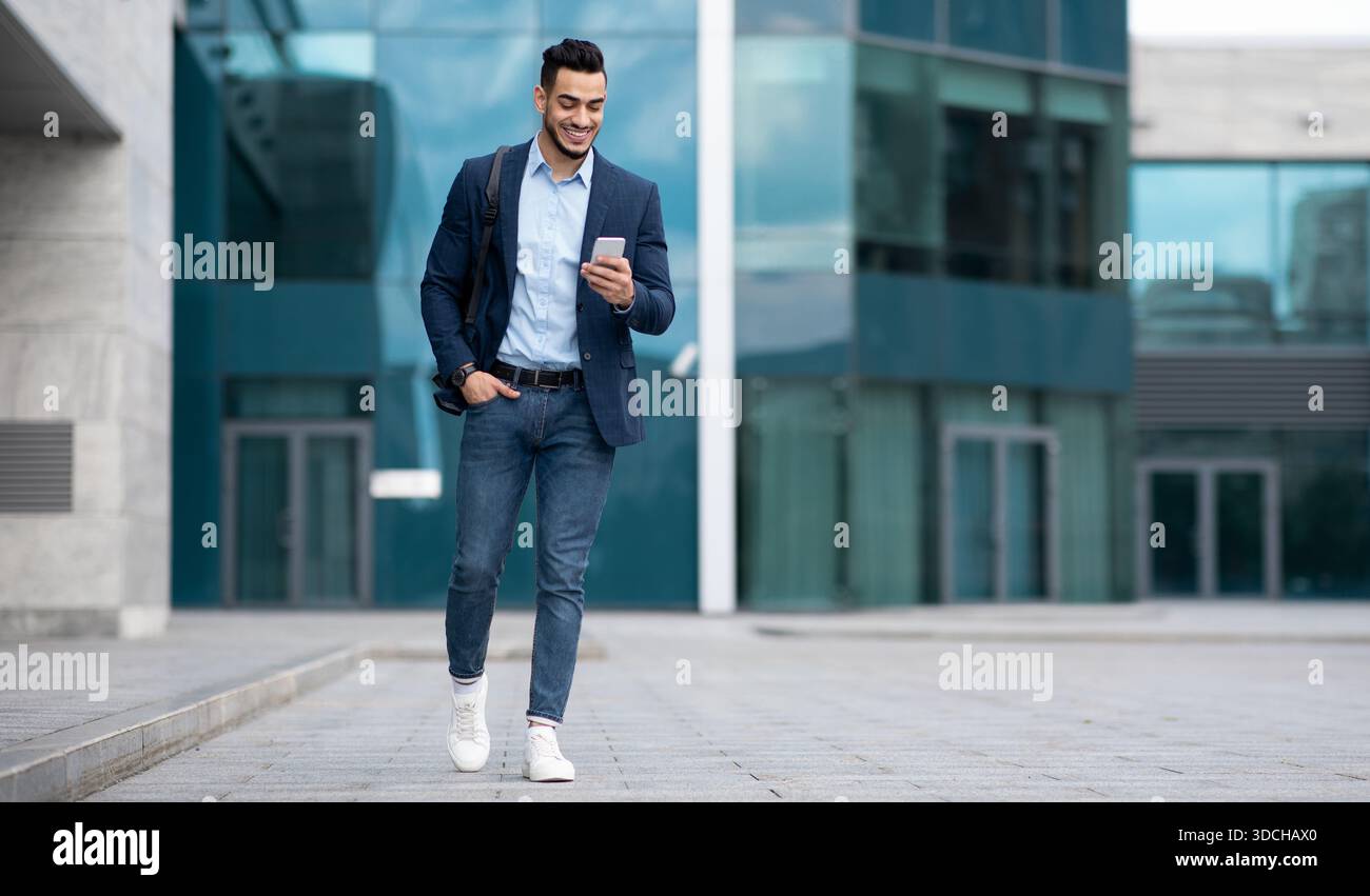 Confident arabic guy programmer with backpack walking by street Stock Photo