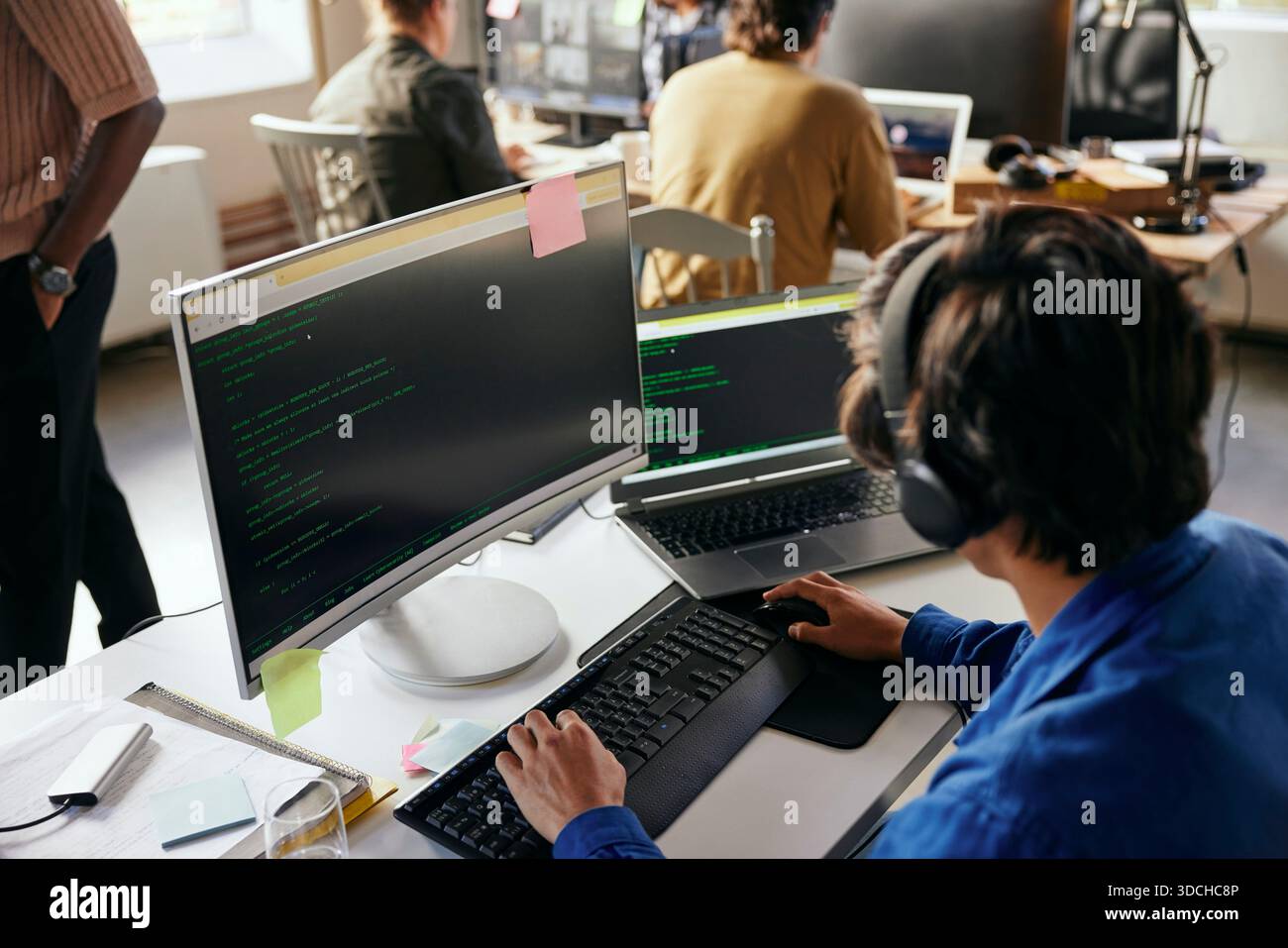 High angle view of young male programmer coding on desktop PC in tech office Stock Photo