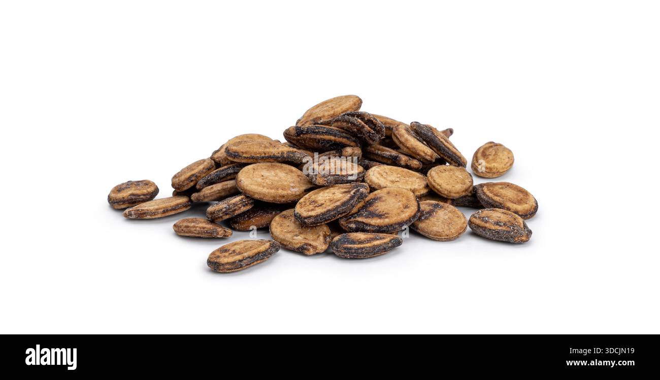 Dried watermelon seeds forming a small pile on a solid white surface Stock Photo