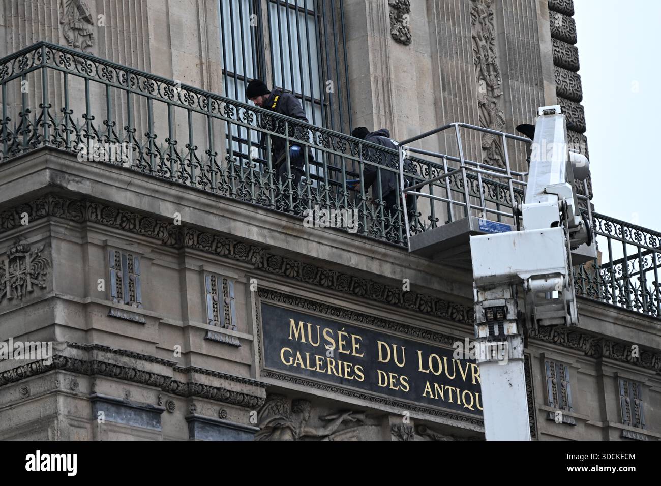 Workers install metal security bars over the window where thieves broke ...